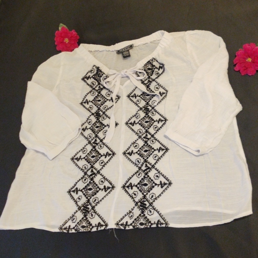 NYCC Semi-transparent white blouse with black embroidery on the front.